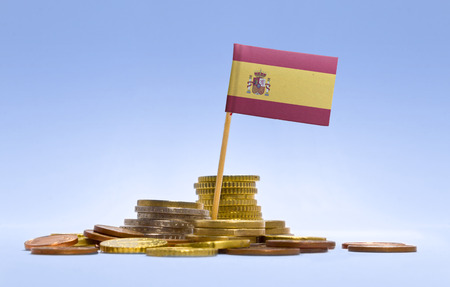 Flag of Spain in a mixed stack of european coins and a blue background.(series)の写真素材