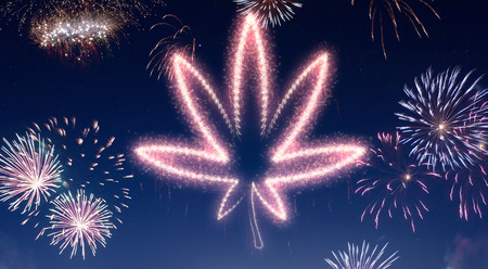 A dark night sky with a sparkling red firecracker in the shape of a weed leaf composed into.(series)の写真素材