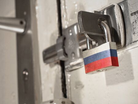 A bolted door secured by a padlock with the national flag of Russia on it.(series)の写真素材