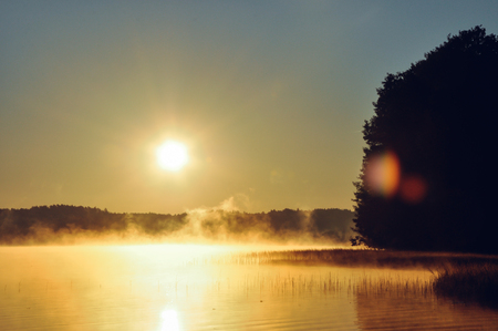 Beautiful sunrise by the lake. Fog on water. Beauty of idyllic nature, ladnscape, poland concept.の写真素材