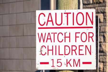 A sign in a housing development under construction warns drivers to watch for children, and sets a speed limit of fifteen kilometers per hour.の写真素材