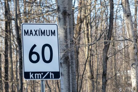 A speed limit road sign in Ontario, Canada has a posted maximum of 60 km/h, or sixty kilometers per hour.の写真素材