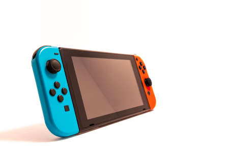 A Nintendo Switch video game console is seen in isolation against a white background, standing up...