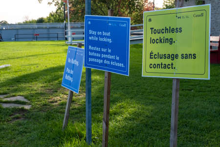 Signs at Merrickville Locks along the Rideau River in Ontario state rules for traversing the locks...