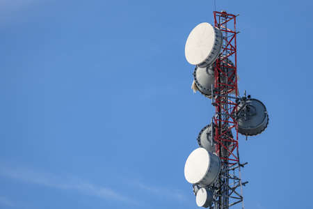 The upper portion of a communications tower holds an array of several microwave backhaul antennas...