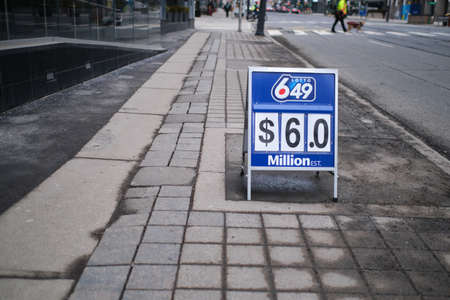 Toronto, Ontario, Canada - March 14, 2022: A signboard on a downtown sidewalk advertises a...