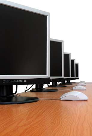 Row of computer monitors in classroom. White background, isolated.