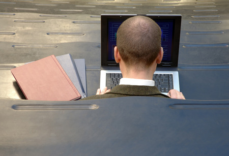 Student with laptop and books sitting in lecture hallの写真素材