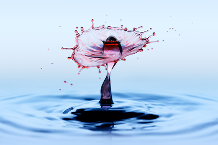 Water splatter and splash. Collision effect of two red falling rain drops.