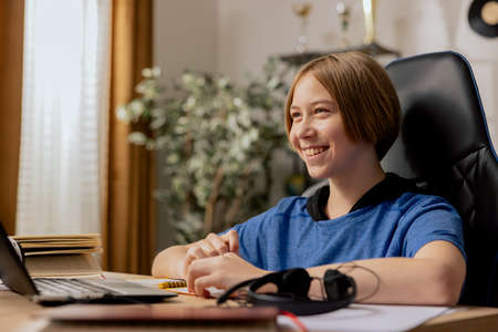 Smiling boy greets online class with teacher, student answers questions, activity, distance...