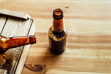 Two beer bottles on a wooden background, copy spaceの写真素材