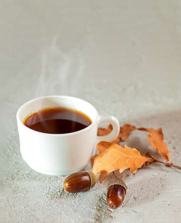Cup of acorn hot coffee, acorns and yellow oak leaves on a gray background. A healthy homemade eco-friendly hot drink without caffeineの写真素材