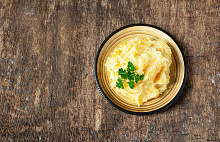 Mashed parsnips with potatoes and carrots on a dark wooden background. Delicious and healthy vegetarian food rich in vitamins and minerals. Top viiew, copy spaceの写真素材