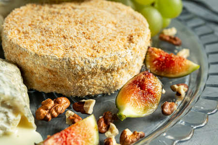 Camembert with grapes, walnuts and figs close-up on the gray backgroundの写真素材