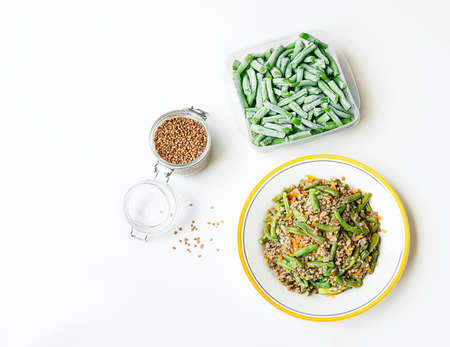 Buckwheat porridge with green beans and ingredients for its preparation - frozen green beens and...
