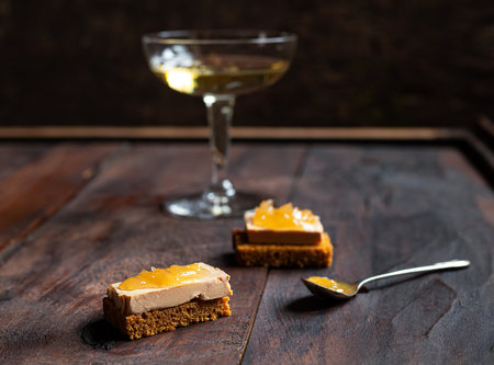 Foie gras toasts with candied onion and gingerbread and a glass of champagne on the dark old backgroundの写真素材