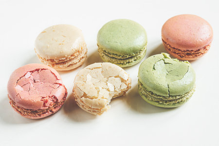 Six multicolored delicious French macaroons or macarons on a light background, close-upの写真素材