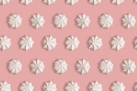 Seamless pattern with meringue cookies on a pink background as creative textureの写真素材
