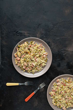 Two plates with traditional Cantonese or Chinese fried rice on a dark table, top viewの写真素材