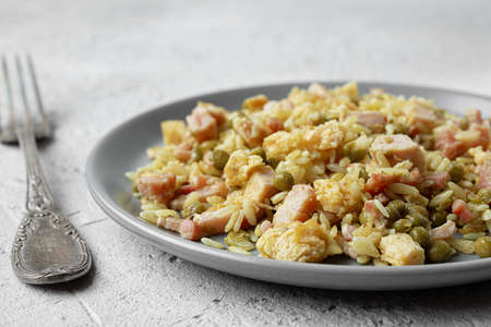 Cantonese rice or Chinese fried rice in a plate on a dark wooden old table, top view