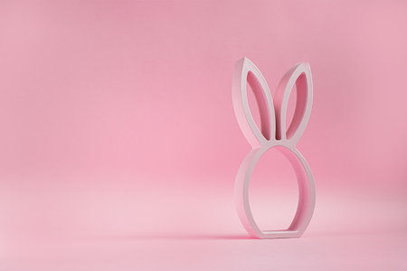 Wooden easter bunny figurine on the pink background, easter minimal concept with copy spaceの写真素材