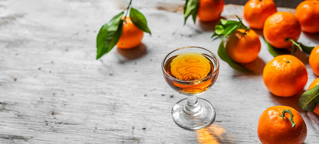 Tangerine liqueur shot and fresh tangerines on a gris background with copy space