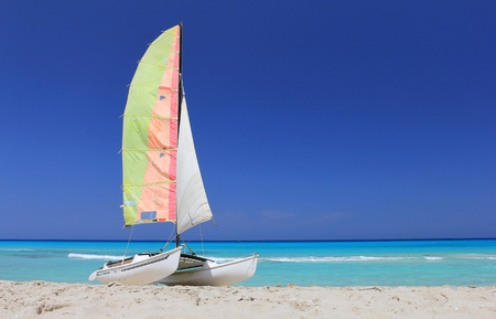 blue sky turquoise Caribbean Sea Atlantic ocean wave relax summer vacation Cuba Cuban beach beachfront white sand sail sheet yacht pleasure boat catamaranの写真素材