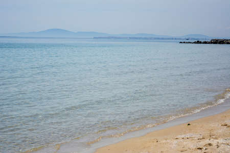 Ravda Bulgaria. May 20 2014. Empty seashore with distant mountain in the horizon. Sandy beach with calm transparent water.の写真素材