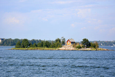 Helsinki, Finland. July, 24, 2014. A small island in Helsinki harbour with trees and wooden red house on it.のeditorial素材