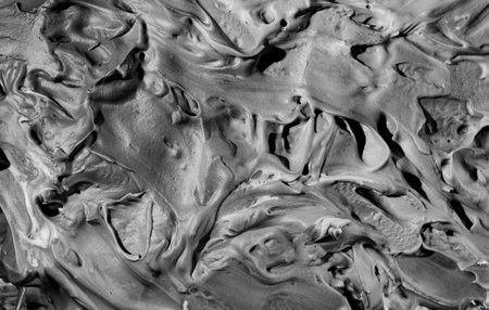 Gray rough surface brutal texture putty foam background with bulky convex structure in hard light with contrast shadowsの写真素材