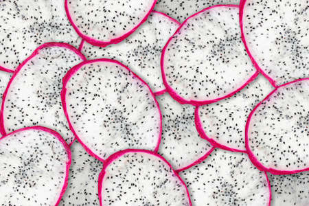 Sliced pitahaya dragon fruit fresh with white pulp and black seeds, compilation background. texture pattern of fruit pitaya.の写真素材