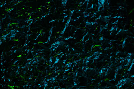 Dark Metal chrome foil texture drammatic effect with crumpled structure and bright lime sparkles. Polygonal dark backgroundの写真素材