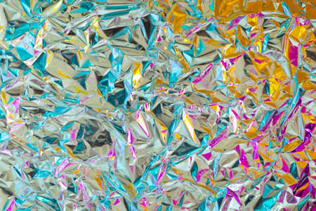 Bright young juicy chrome bold crumpled texture foil with gradient color of magenta and yellow. Amazing fusion futuristic background. Good for party, rave, disco and young designの写真素材