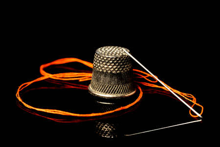 needle with thread and thimbleの写真素材