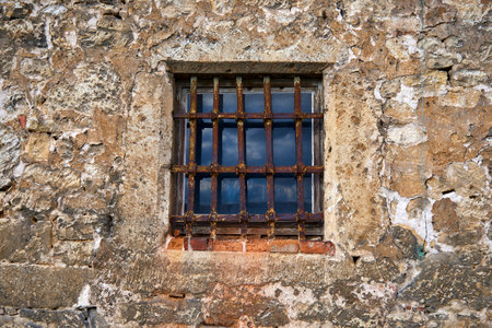 An old window in the castle with a rusty steel grate