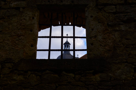 view of the spire in the window with barsの写真素材