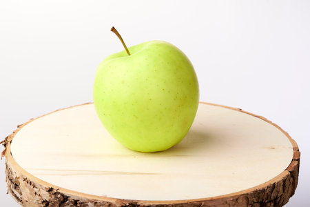 Green apple on a wooden standの写真素材