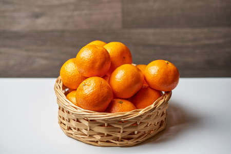 Basket with tangerines on a light backgroundの写真素材