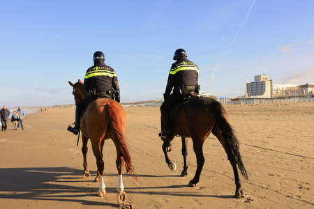 Scheveningen, The Hague, The Netherlands, 22 January 2021: two policemen riding a horse on a beach in Scheveningen, The Hague, The Netherlandsのeditorial素材