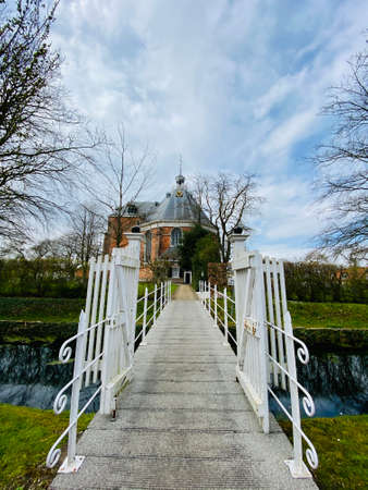 White beautiful bridge way to old Dutch church in Willemstad in the Netherlands, blue sky backgroundの写真素材