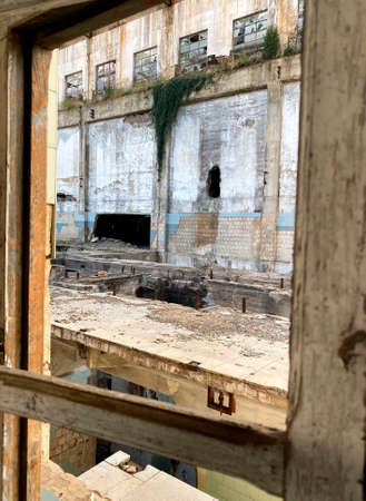 Looking through the window of the interior of an abandoned factoryの写真素材