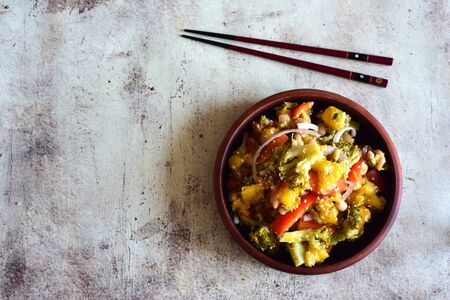 Korean spicy salad in clay plate with chopsticks on grey backgroundの写真素材