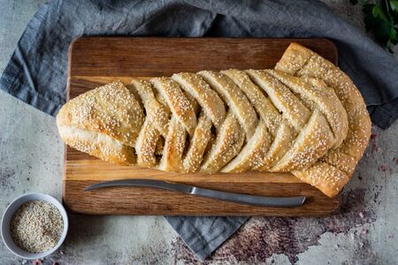 Yeast fish pie sprinkled with sesame on a wooden Board on a gray background. The view from the topの写真素材