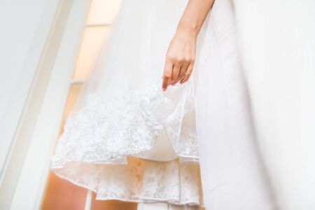 Bride's dress and hand on wedding day. Getting readyの写真素材