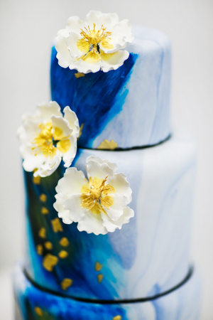 Multi level blue wedding cake with flowers.の写真素材
