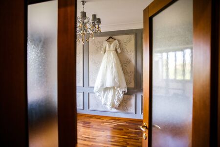 Wedding dress hanging on the wall in the room.の写真素材