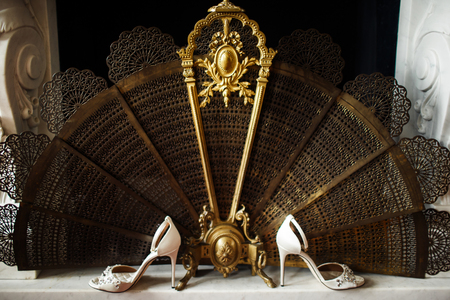 Wedding shoes near the metal fireplace shutter.の写真素材