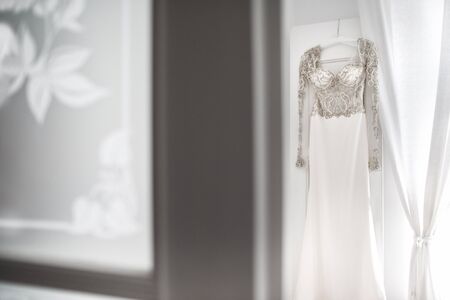Wedding dress hanging on the wall in the room.の写真素材