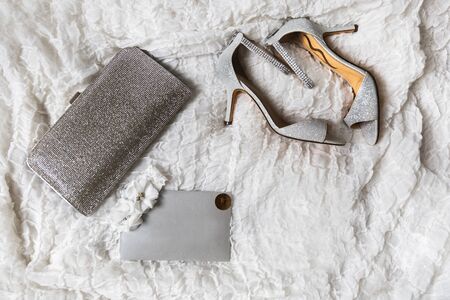 Wedding shoes, purse and garter on a gray background.の写真素材
