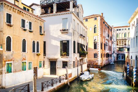 Boat moored between colorful houses. Canals in Venice, Italy.の写真素材